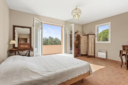 une chambre avec un grand lit et une grande fenêtre dans l'établissement Villa familiale la Croix-du-Sud, à La Croix-Valmer