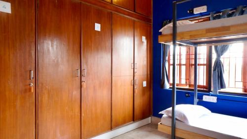 a room with wooden cabinets and a bunk bed at Roambay - Gokulam in Mysore