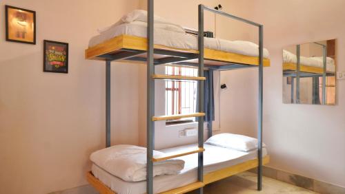 a bunk bed room with bunk beds and a mirror at Roambay - Gokulam in Mysore
