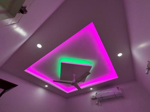 a purple room with a purple ceiling with a tv at Puzhayoram Homestay in Trichūr