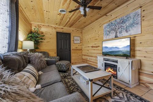 a living room with a couch and a fireplace at Strawberry Wine Romantic Hot Tub Cabin in Pigeon Forge