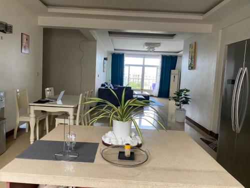 a living room with a table with a plant on it at Masaki Anne H & Apartment in Dar es Salaam