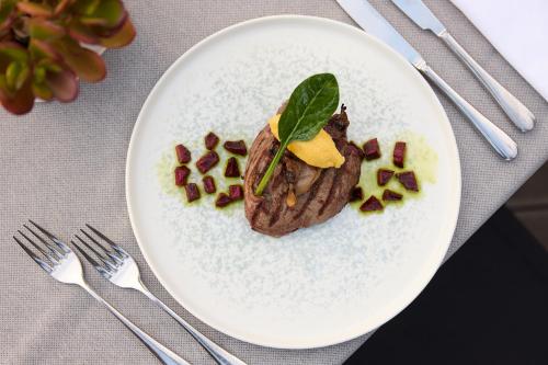 a white plate with a piece of food on a table at Domotel Xenia Volos in Volos