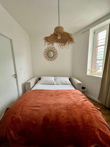 une chambre avec un grand lit avec une couverture rouge dans l'établissement The Cosy Place, à Toulouse