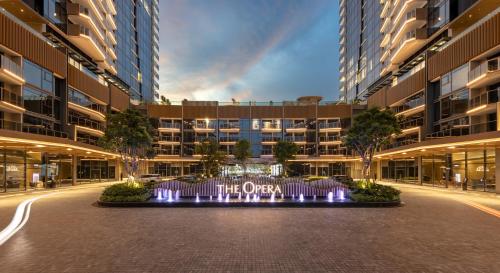 a large building with a water fountain in the middle at The Metropole Opera Residence by KayStay in Ho Chi Minh City