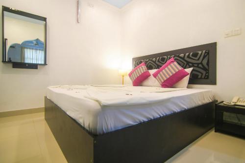 a bedroom with a large bed with pink pillows at Azoush Tourist Guesthouse in Fulhadhoo