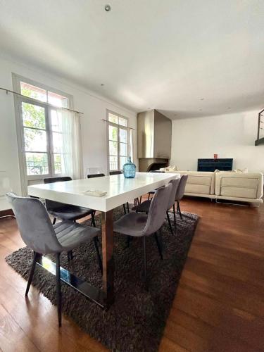 une salle à manger avec une table et des chaises blanches dans l'établissement Loft Garonne - Centre ville immeuble privatif, à Toulouse