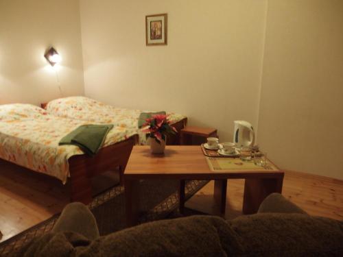 Un dormitorio con una cama y una mesa de madera con una mesa. en Parks Guest House en Sigulda