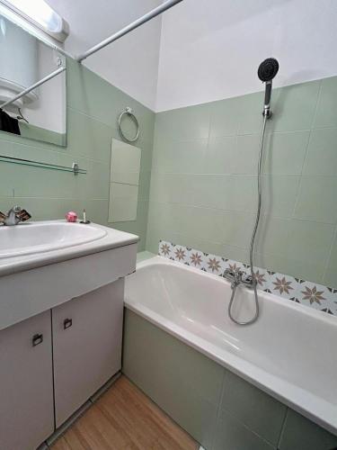 une salle de bain avec un lavabo, une baignoire et une douche dans l'établissement Au Charme des Carmes - T1 sur cour - Métro A & B, à Toulouse