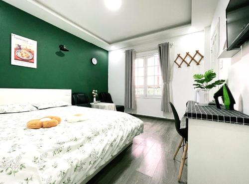 a green bedroom with a bed with two donuts on it at DORA Boutique Hotel Dalat in Da Lat