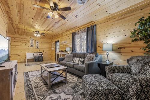a living room with a couch and a ceiling fan at Strawberry Wine Romantic Hot Tub Cabin in Pigeon Forge