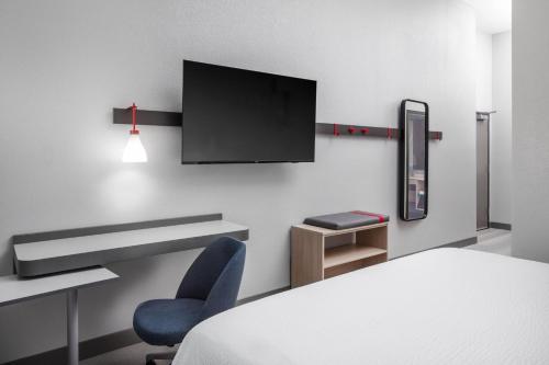 a room with a bed and a tv on a wall at avid hotel North Platte by IHG in North Platte