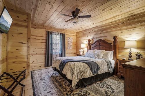 a bedroom with a bed and a ceiling fan at Strawberry Wine Romantic Hot Tub Cabin in Pigeon Forge