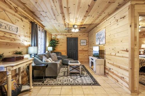 a log cabin living room with a couch and a table at Strawberry Wine Romantic Hot Tub Cabin in Pigeon Forge