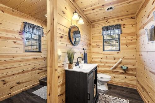 a log cabin bathroom with a sink and a toilet at Strawberry Wine Romantic Hot Tub Cabin in Pigeon Forge