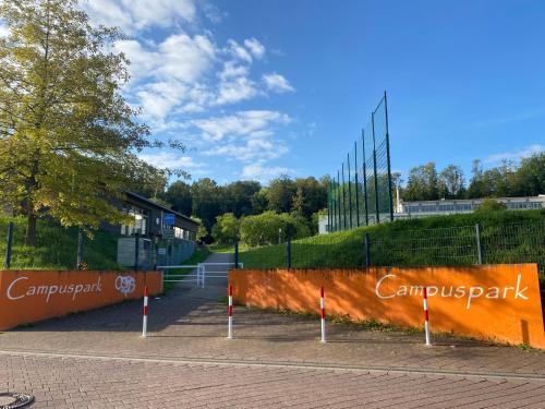 a parking lot with an orange wall with a fence at Sonnenschein in Baden-Baden