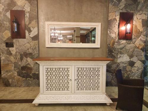 a mirror on top of a dresser in a room at Adique's Resorts in Marawila