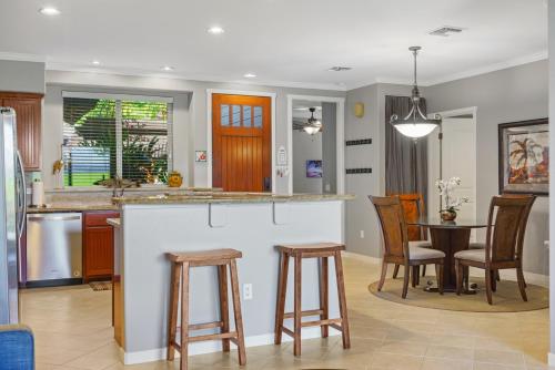 a kitchen with a bar and a table and chairs at Golf Villas At Mauna Lani A3 in Waikoloa