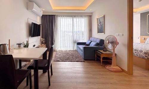 un salon avec un canapé bleu et une table dans l'établissement Aristo-2-805, à Ban Lum Fuang