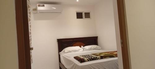 una camera da letto con un letto in una stanza bianca di Ricks place a Guayaquil