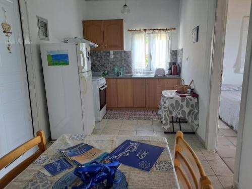 a kitchen with a table and a white refrigerator at BIZOS Beach in Koroni