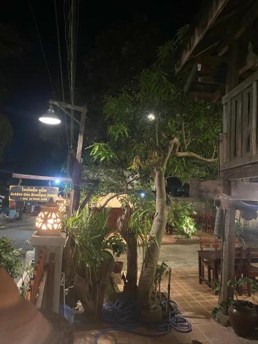 a tree in front of a building at night at Golden Sun Boutique Hotel in Luang Prabang