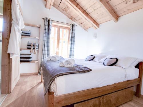 une chambre avec un lit avec des draps blancs et une fenêtre dans l'établissement Chalet d'Exception: Ferme 200 ans Rénovée avec Sauna & Spa - FR-1-623-18, aux Gets