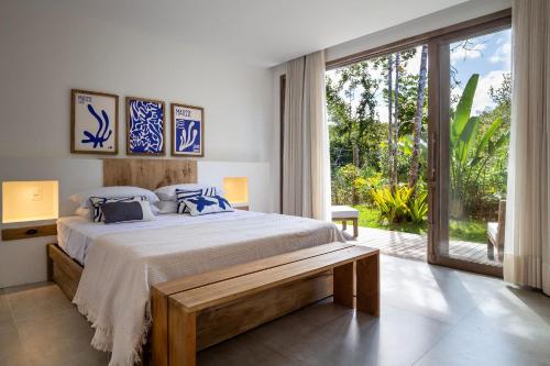 a bedroom with a large bed and a large window at Villa da Lua - Aconchego e sofisticação em meio à natureza in Arraial d'Ajuda