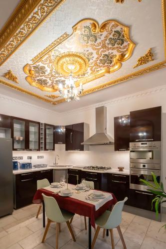 a kitchen with a table with chairs and a ceiling at Finchley Road Studios & Apartments by PrimeCityHosts in London