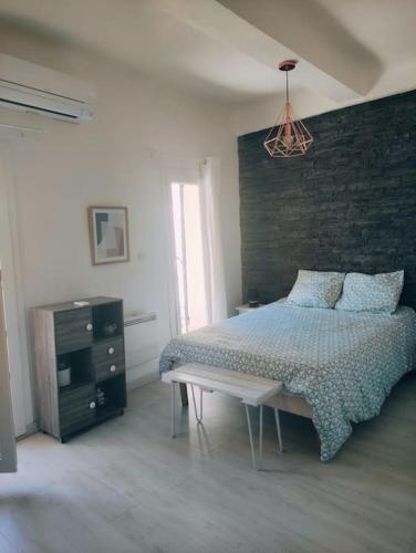 une chambre avec un lit et un mur de briques dans l'établissement Appartement Marina, à Gardanne