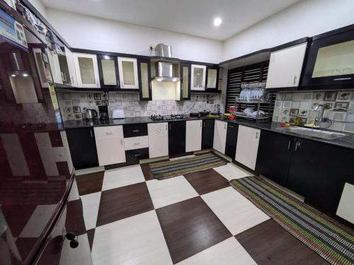 a kitchen with black and white checkered floor at Villa Del Sol - South Cliff, Varkala in Varkala