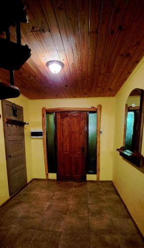 an empty room with a wooden door and a ceiling at Cabañas y Casa Kauken in Puerto Natales