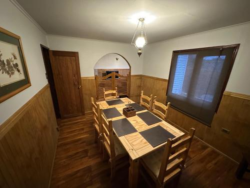 a dining room with a table and wooden chairs at Cabañas y Casa Kauken in Puerto Natales