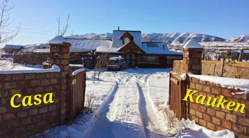 a house in the snow with a fence at Cabañas y Casa Kauken in Puerto Natales