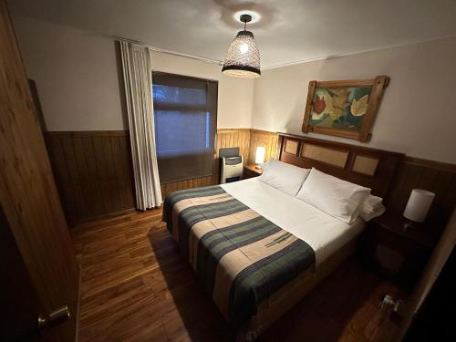 a hotel room with a bed and a window at Cabañas y Casa Kauken in Puerto Natales