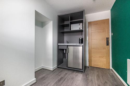 a small kitchen with a sink and a refrigerator at NE1 City Studios & Apartments in Newcastle upon Tyne