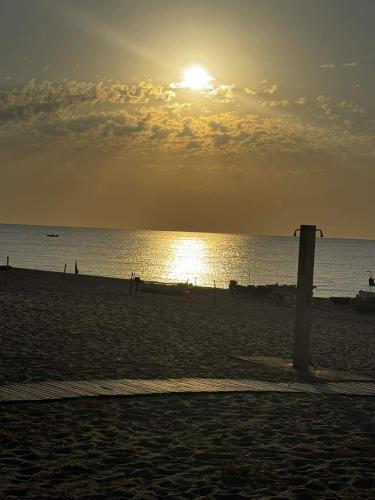 a sunset on a beach with a trash can at Casa Maria in Locri