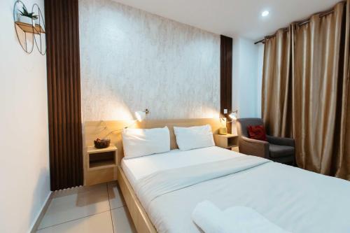 a bedroom with a large white bed and a chair at Modern Studio Suite at The Gallery in Accra