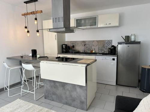 une cuisine avec un réfrigérateur et un plan de travail dans l'établissement Maison de ville à Châtellerault, à Châtellerault