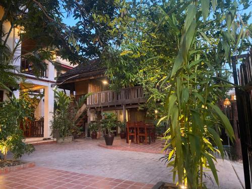 a courtyard of a house with a wooden deck at Golden Sun Boutique Hotel in Luang Prabang