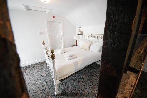 a bedroom with a white bed with white sheets and pillows at Without A Paddle Hotel in Llangollen