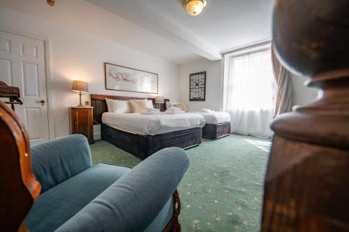 a hotel room with two beds and a couch at Without A Paddle Hotel in Llangollen