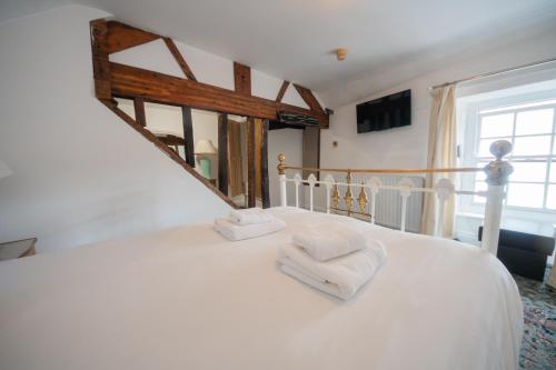a bedroom with a white bed with towels on it at Without A Paddle Hotel in Llangollen