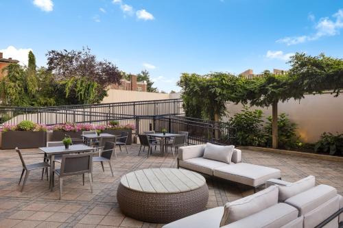 a patio with tables and couches and tables and chairs at Courtyard New Haven at Yale in New Haven
