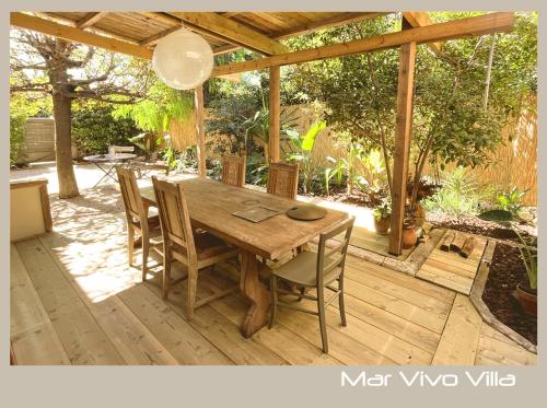 une table et des chaises en bois sur une terrasse en bois dans l'établissement MarVivo Villa - Rez de Jardin - Plage 3' à pied, à La Seyne-sur-Mer
