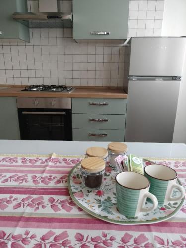a kitchen with a table with a plate with cups on it at Corte Vitelleria in Piazza
