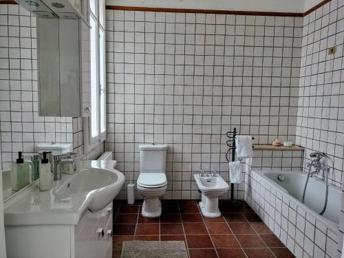 a bathroom with a tub and a toilet and a sink at Corte Vitelleria in Piazza