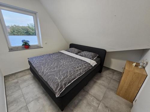a small bedroom with a bed and a window at Neubau Ferienwohnung mit Balkon in Gronau
