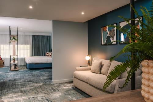 a living room with a couch and a bed at voco Winchester Hotel & Spa by IHG in Winchester