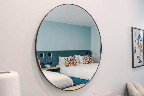 a mirror in a bedroom with a bed at voco Winchester Hotel & Spa by IHG in Winchester